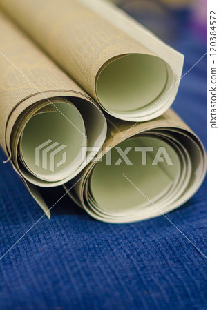 three small rolls of wallpaper on blue background . High quality photo 120384572