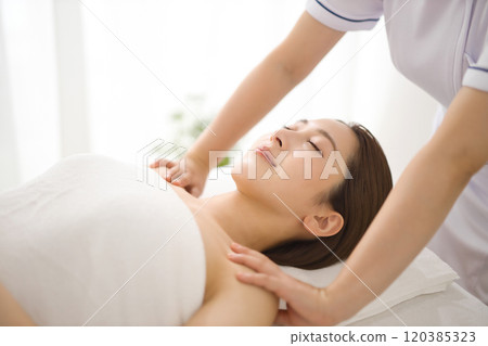 Woman receiving a massage from an esthetician 120385323