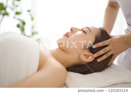 Young woman receiving a massage from an esthetician Young woman receiving a massage from an esthetician 120385324
