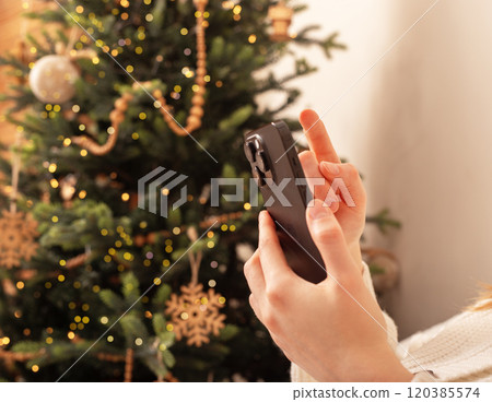 Lodz Poland July 20 2024, hands holding and using mobile phone, iphone smartphone on Christmas Lodz Poland July 20 2024, hands holding and using mobile phone, iphone smartphone on Christmas 120385574