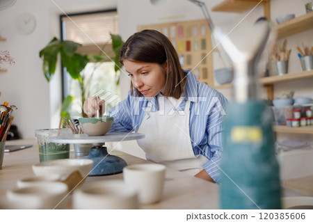 Engaging in Artisan Pottery Creation within a Cozy and Inviting Studio Atmosphere Engaging in Artisan Pottery Creation within a Cozy and Inviting Studio Atmosphere 120385606