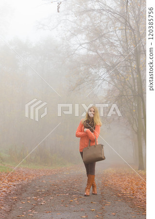 Happy fashion woman with handbag in autumn park 120385756
