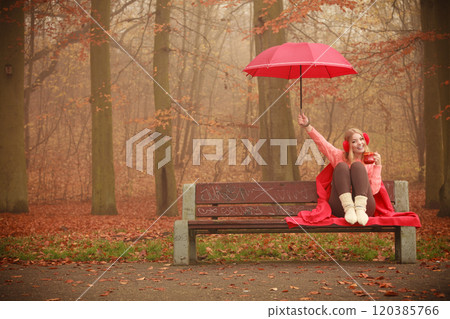 Girl in autumn park enjoying hot drink Girl in autumn park enjoying hot drink 120385766
