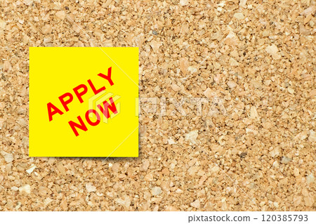 Yellow note paper with word apply now on cork board background with copy space 120385793