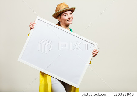 Happy cheerful woman holding blank white board Happy cheerful woman holding blank white board 120385946
