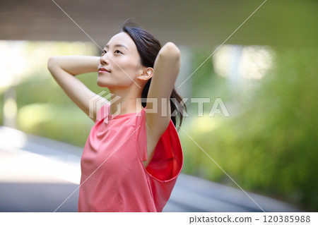 A young woman in sportswear standing in the greenery A young woman in sportswear standing in the greenery 120385988
