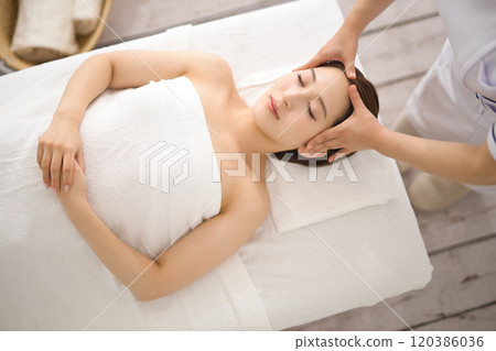 Young woman receiving a massage from an esthetician Young woman receiving a massage from an esthetician 120386036