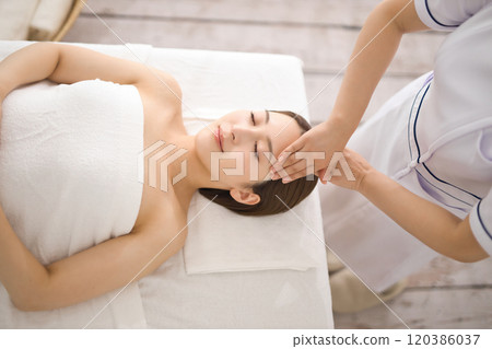 Young woman receiving a massage from an esthetician Young woman receiving a massage from an esthetician 120386037