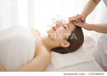 Woman receiving a massage from an esthetician Woman receiving a massage from an esthetician 120386097