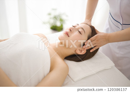 Woman receiving a massage from an esthetician 120386137
