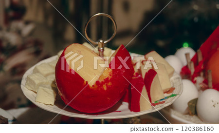 A plate featuring sliced red queso de bola a semi-hard, ball-shaped cheese that's a staple in Filipino culture and a common part of Christmas and New Year celebrations 120386160