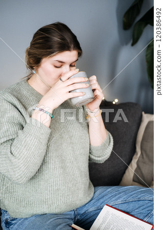 Pregnant woman with warm drink, embracing slow living. Intentional motherhood, self-care, and calm during pregnancy. 120386492