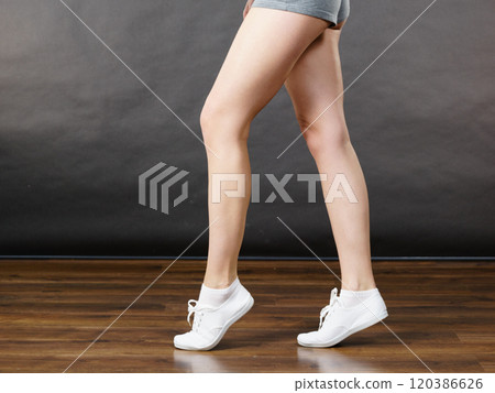 Woman wearing grey shorts, legs only 120386626