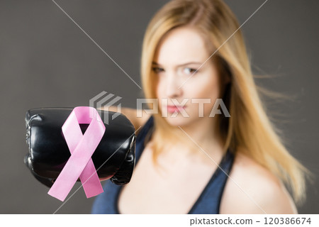 Woman wearing boxing gloves having pink ribbon Woman wearing boxing gloves having pink ribbon 120386674