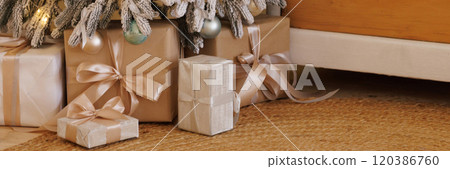 Banner a Christmas tree with lights and ornaments sits next to a wooden dresser 120386760