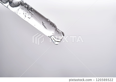 Pipette with facial serum pouring out of it on grey background. 120389322