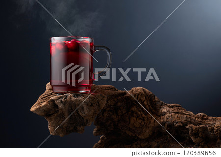 Hot drink with cranberries and lime on a old wooden snag. 120389656