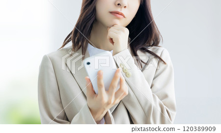 拿著智慧型手機的一位擔心的女商人 拿著智慧型手機的一位擔心的女商人 120389909
