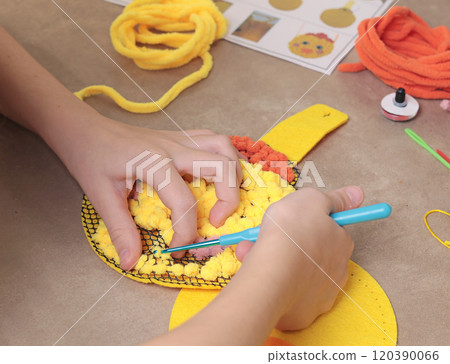 Teenage girl doing handcraft, sewing purse from threads. Hobby and creativity, useful pastime. Teenage girl doing handcraft, sewing purse from threads. Hobby and creativity, useful pastime. 120390066