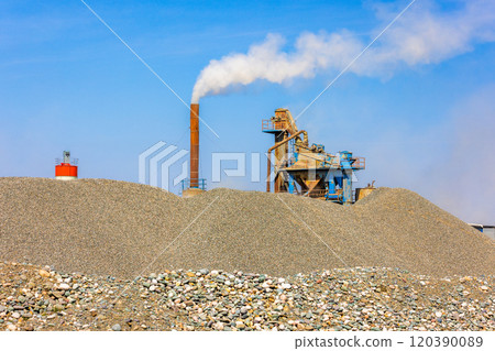 white steam rising up from pipe of small asphalt factory at day time with piles of gravel in a foreground white steam rising up from pipe of small asphalt factory at day time with piles of gravel in a foreground 120390089