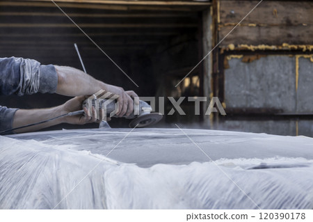 Hands of the auto repairman grinding roof of the car. Hands of the auto repairman grinding roof of the car. 120390178