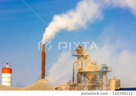 white steam rising up from pipe of small asphalt factory at day time with piles of gravel in a foreground white steam rising up from pipe of small asphalt factory at day time with piles of gravel in a foreground 120390212