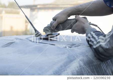 Hands of the auto repairman grinding roof of the car. Hands of the auto repairman grinding roof of the car. 120390230