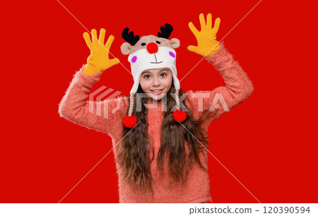 Winter child wardrobe. Teenage girl in Xmas hat isolated on red. Winter fashion for teenage style. Girl in knitted hat in winter season. Childhood lifestyle. Earflap fashion 120390594