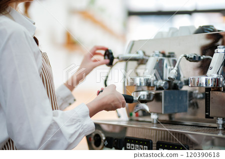 Dedicated barista preparing coffee, demonstrating professionalism and skill in a cafe setting. 120390618