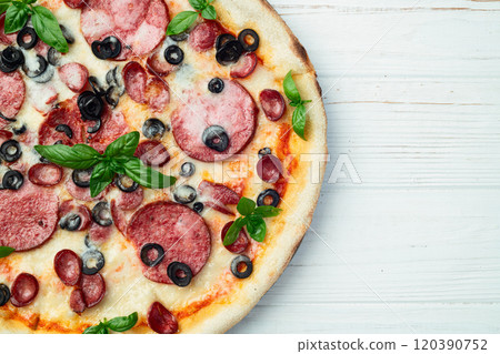 Pizza with mozzarella cheese , salami sausages , olives , and basil Pizza with mozzarella cheese , salami sausages , olives , and basil 120390752