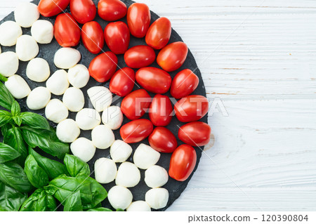 Basil leaves , cherry tomatoes and mozzarella cheese . In form italian flag food photography 120390804
