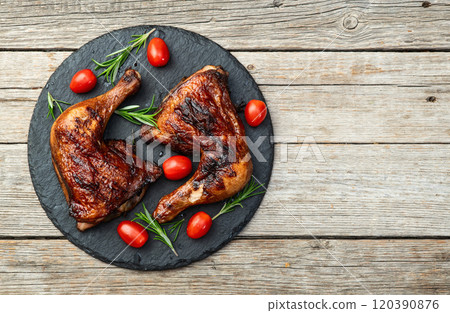 Grilled chicken legs with tomatoes and salad . Top view 120390876