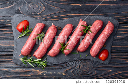 Raw beef sausages with rosemary and tomatoes photography . Top view 120391018