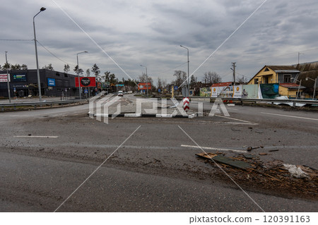 Cities of Ukraine after the Russian occupation. Ammunition shells are lying on the road. Destroyed roads. 120391163