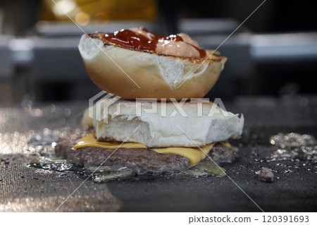 Hamburger being prepared on a moving hot plate Hamburger being prepared on a moving hot plate 120391693