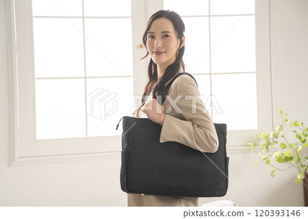 Businesswoman standing by a window indoors Businesswoman standing by a window indoors 120393146