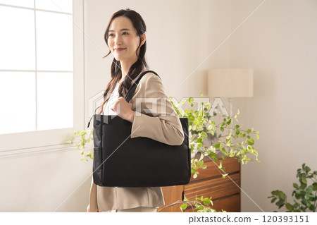 Businesswoman standing by a window indoors Businesswoman standing by a window indoors 120393151