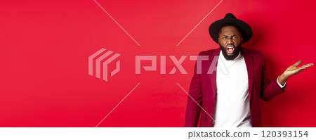 Angry and confused Black man arguing, shouting at camera and raising hand bothered, cant understand something, red background Angry and confused Black man arguing, shouting at camera and raising hand bothered, cant understand something, red background 120393154