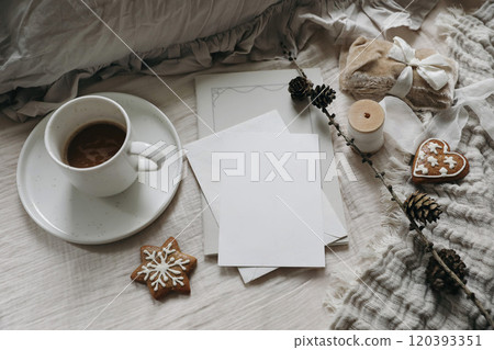 Christmas stationery still life. Blank greeting crad, invitation mockup. Silk, velvet ribbons, gingerbread cookies. Cup of coffee, larch cones on table. Gift wrapping, craft concept. Flatlay, top Christmas stationery still life. Blank greeting crad, invitation mockup. Silk, velvet ribbons, gingerbread cookies. Cup of coffee, larch cones on table. Gift wrapping, craft concept. Flatlay, top 120393351