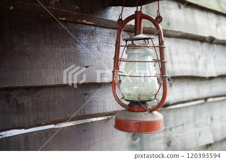Antique rusty kerosene lantern on wooden wall. Antique rusty kerosene lantern on wooden wall. 120393594
