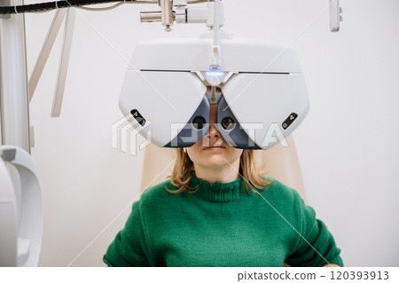 Patient undergoing advanced vision test with modern optometry equipment in clinic 120393913