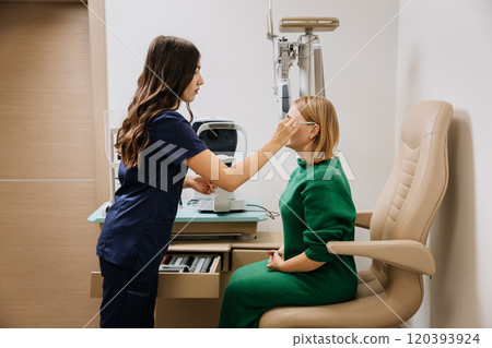 Optometrist fitting trial lenses on eye exam for vision testing and prescription adjustment 120393924