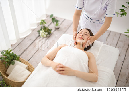 Woman receiving a massage from an esthetician 120394155