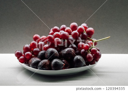 Plate of fresh red grapes and figs 120394335