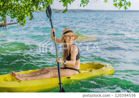 Woman kayaking on Bacalar Lake in Mexico. Adventure tourism in Quintana Roo, outdoor exploration, and water activities concept Woman kayaking on Bacalar Lake in Mexico. Adventure tourism in Quintana Roo, outdoor exploration, and water activities concept 120394556
