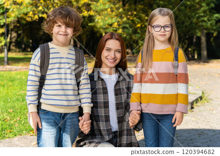 Volunteer or camp teacher spending time with kids in park Volunteer or camp teacher spending time with kids in park 120394682
