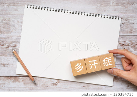 Block, notebook and hand with written word Hyperhidrosis 120394735