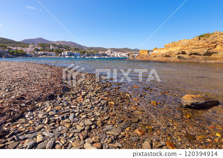 Pebble Shoreline and Village View in Cadaques, Spain 120394914