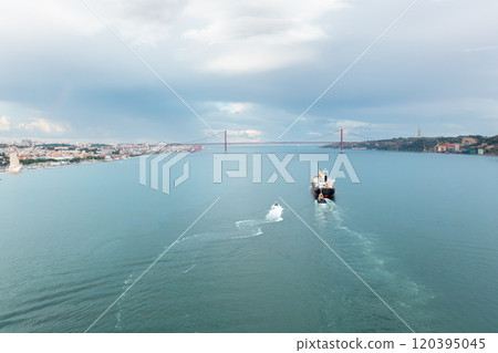 Merchant ship moving on Tagus river with 25 de 120395045