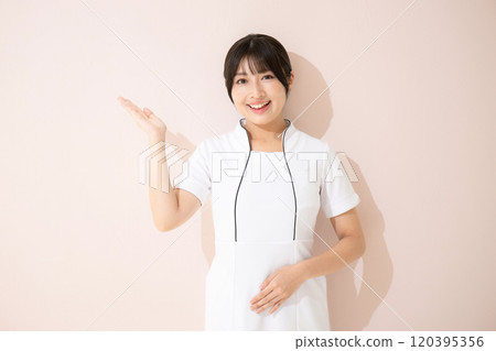 Recommendation, introduction, counseling pose for beauty salons and beauty nurses, looking at the camera on a pink background Recommendation, introduction, counseling pose for beauty salons and beauty nurses, looking at the camera on a pink background 120395356